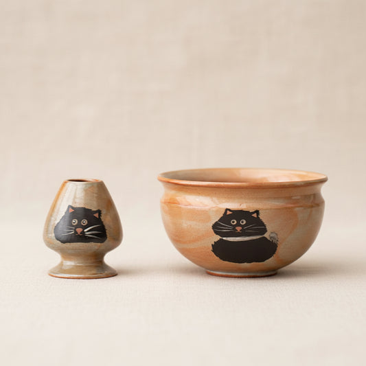 Two ceramic bowls with cat illustrations on a dark background