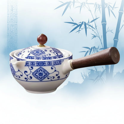 Ceramic pot with blue patterns and wooden handle on a white background