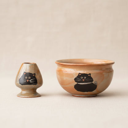 Two ceramic bowls with cat illustrations on a dark background