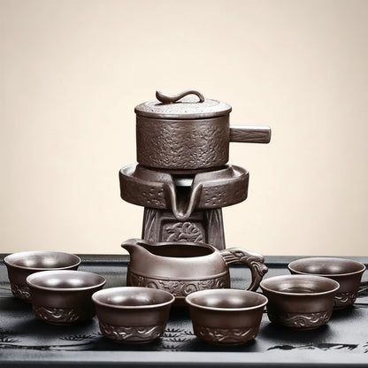 Ceramic tea set with teapot, teacup, and small pot on a dark background