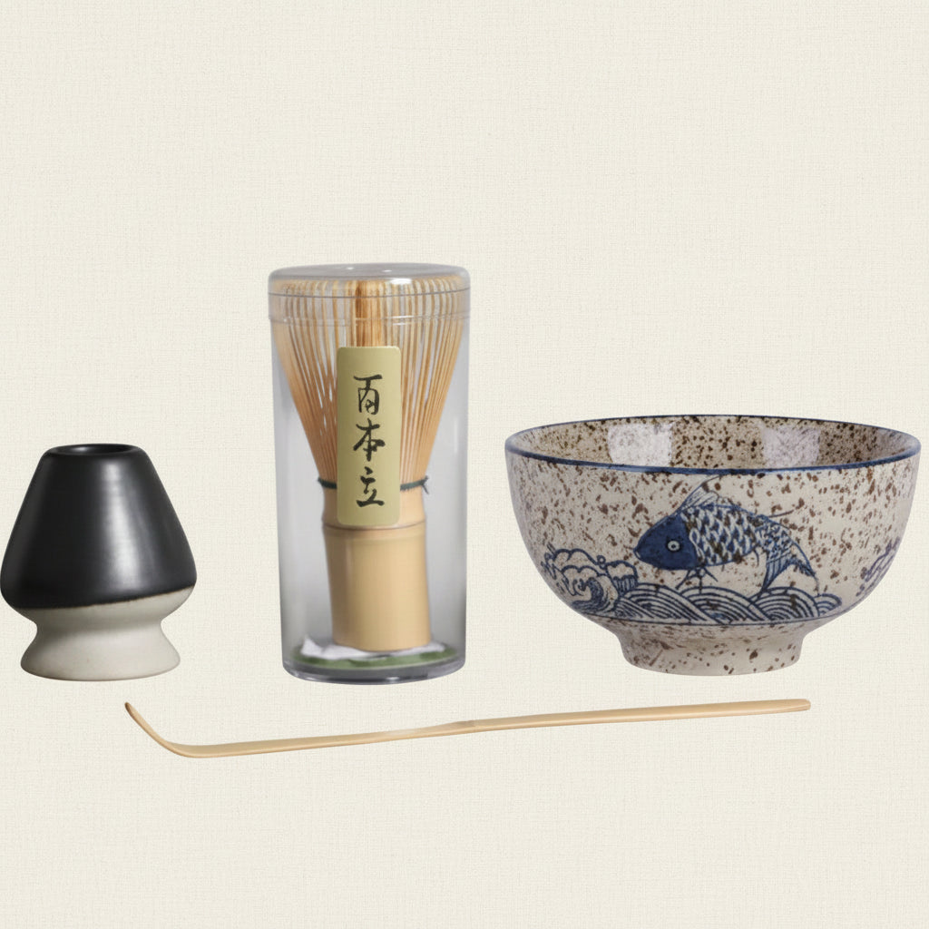 Tea-making set with a ceramic bowl, whisk, and other tools on a gray background