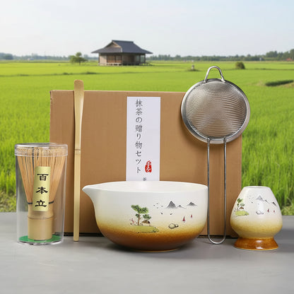 Tea-making set with bowl, whisk, and other tools on a gray surface.