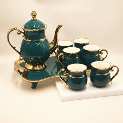 Tea set with green teapot and cups on a white background